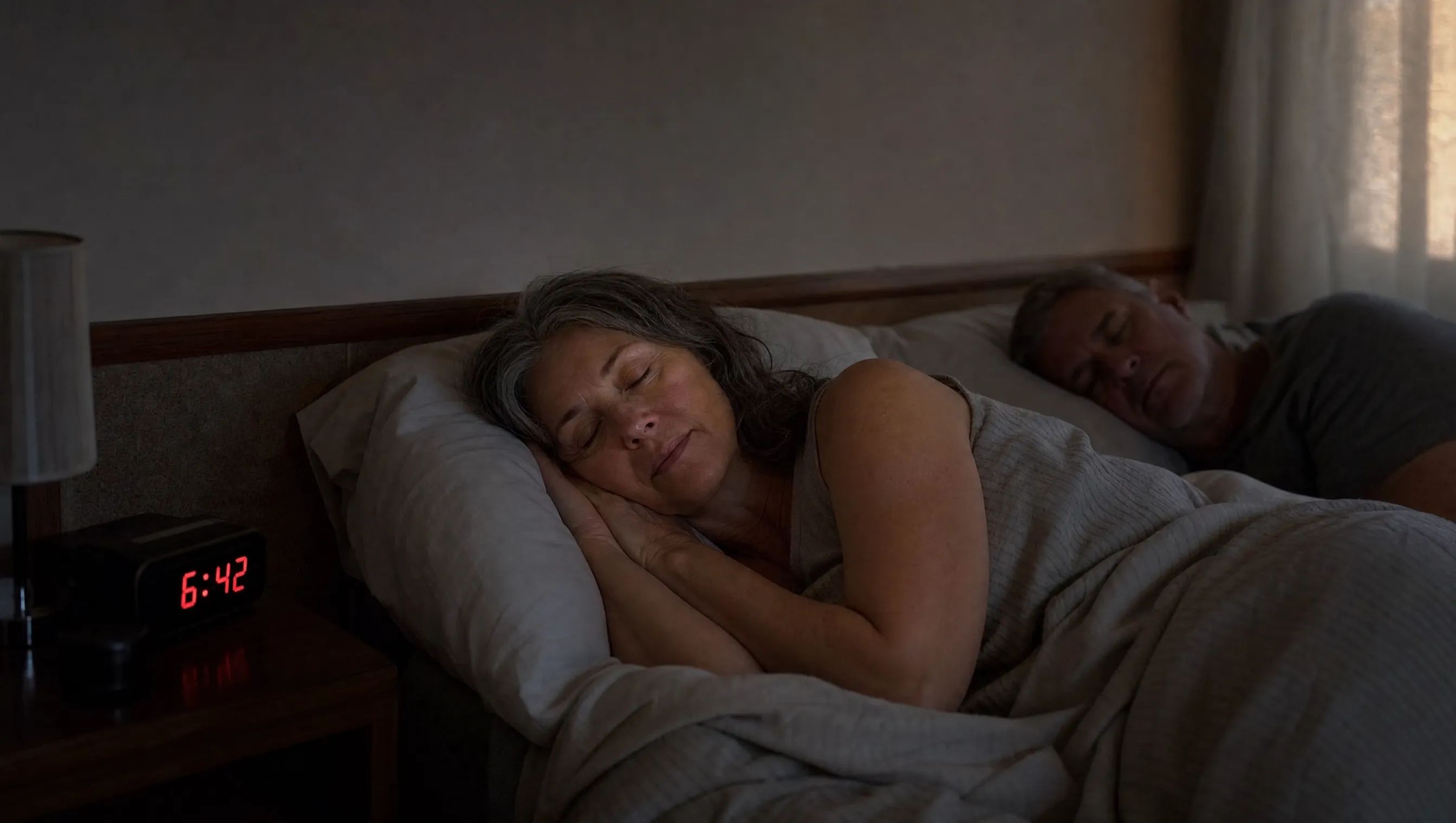 The same woman sleeping peacefully at 6:42am, partner beside her